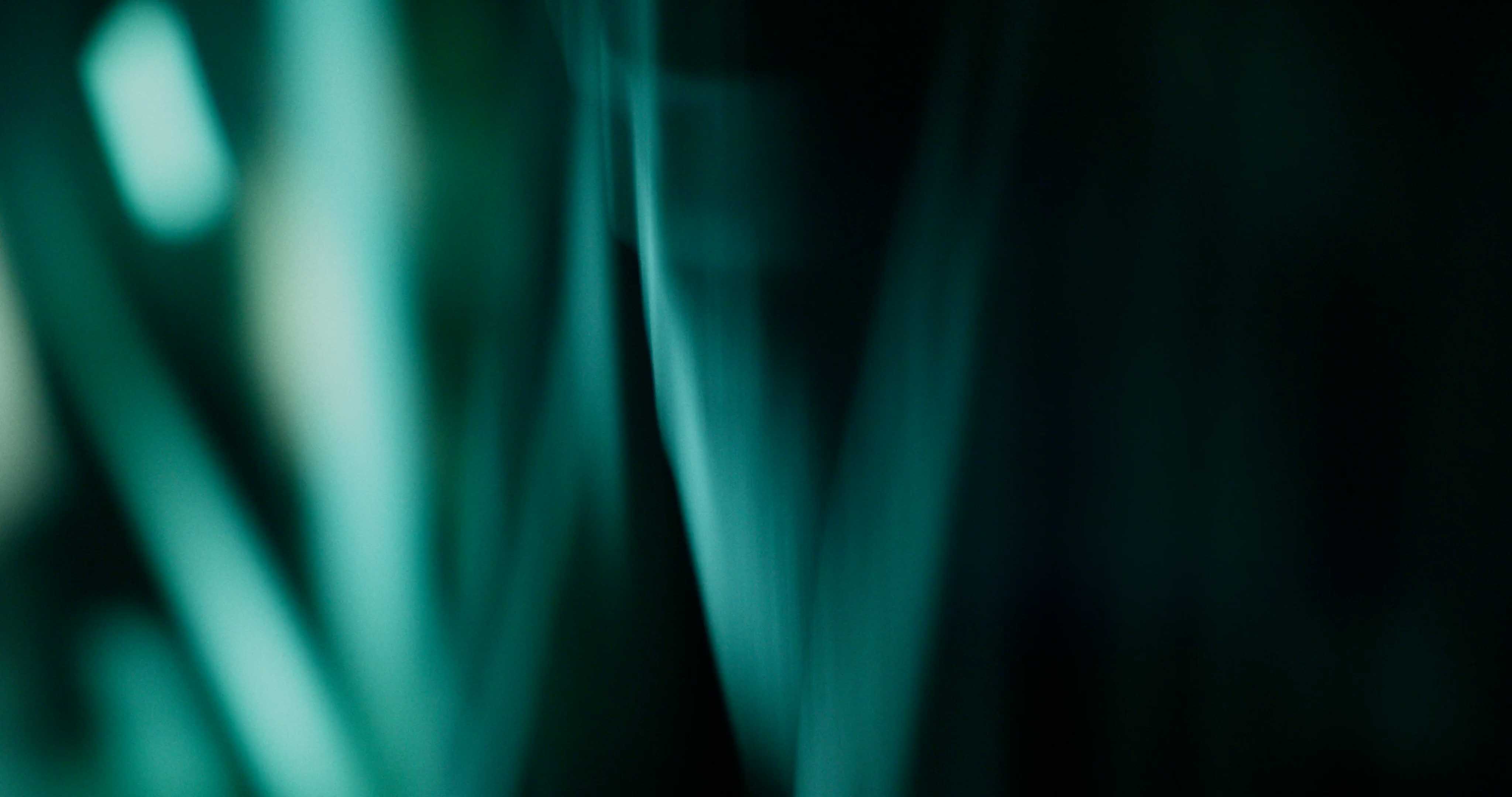 Front-facing Porsche GT3 with headlights on, carving through a chicane at twilight in alpine scenery.